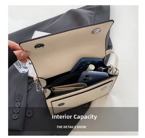Vista della capacità interna di una borsa a tracolla bianco crema con vari scomparti