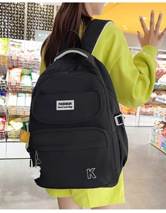 Detail of waterproof black nylon school backpack with zipper compartments and side buckles