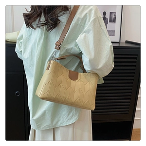 Detail of vintage tote bag with chevron stitching and brown leather top handle strap