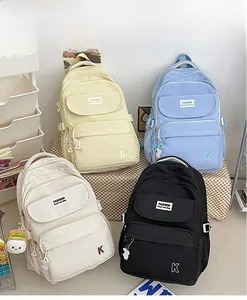 Detail view showing minimalist waterproof nylon backpacks in yellow, blue, white, and black