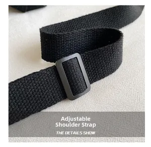 Detail of adjustable black woven shoulder strap with rectangular buckle on canvas tote bag