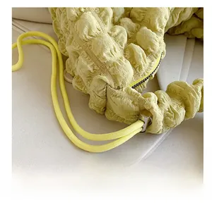 Detailed macro view of yellow bubble cloud bag texture with adjustable drawstring cords