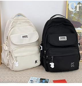Detail of waterproof nylon backpacks in beige and black with cute puppy charms