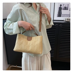 Detail of elegant beige handbag with V-shaped stitching and contrasting brown handles