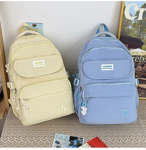 Detail view of water-resistant fashion school backpacks in beige and light blue colors