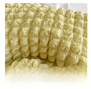 Macro detail of soft light yellow bubble textured fabric showing puffy 3D cloud pattern