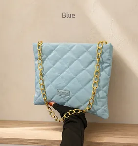 Close-up of light blue quilted bucket bag with gold chain and Fashion logo detail