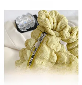 Macro shot of high-quality silver metal zipper on soft yellow bubble textured bag