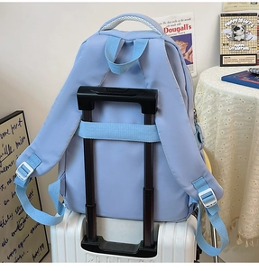 Detail view of water-resistant light blue backpack with a luggage strap for travel