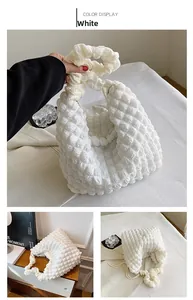 Detail view of the white bubble texture fabric and ruched handle on a soft hobo bag