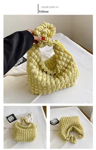 Detail of yellow cloud bag featuring textured bubble fabric and pleated handle design