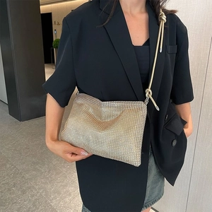 Detailed close-up of champagne gold rhinestone mesh bag with elegant knotted strap design