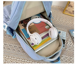 Top view of open light blue school backpack showing spacious interior and textbooks