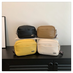 Group display of four textured lychee pattern camera bags in black, khaki, yellow and beige