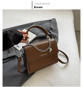 Dettaglio della borsa a tracolla in pelle PU marrone con catena e testo Fashion
