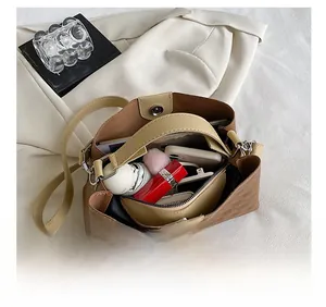 Internal view of brown woven tote showing large capacity compartments and magnetic closure