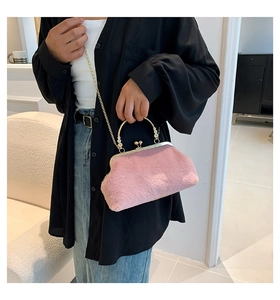Detail of pink faux fur crossbody bag with golden spherical clasp and metal chain strap
