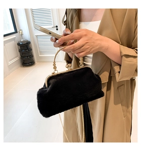 Detailed view of plush black faux fur handbag with golden metal frame and chain strap