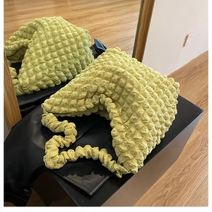Close-up of soft yellow popcorn fabric texture and pleated handle on cloud shoulder bag
