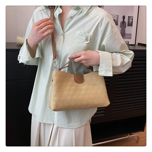 Detail of light beige tote bag with 3D honeycomb texture and dark brown leather straps