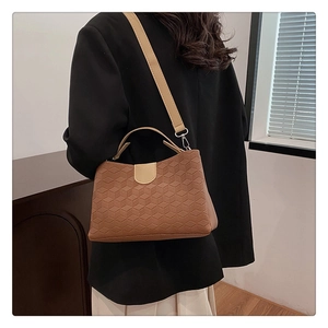 Detailed back view of a brown geometric embossed leather shoulder bag with a top handle