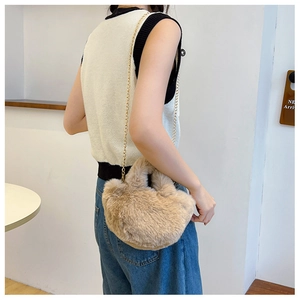 Nahaufnahme einer Plüsch-Handtasche in Khaki mit goldener Kette an einem Model präsentiert