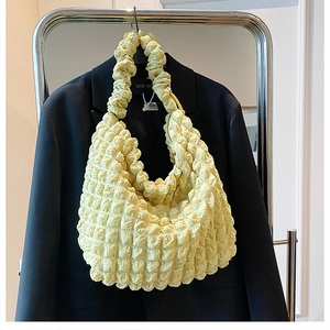 Detail of light yellow popcorn texture fabric on a large capacity hobo cloud shoulder bag