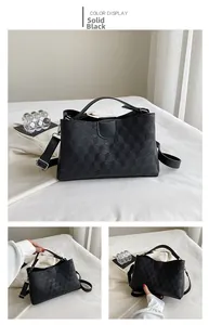 Detail view of pure black tote bag with geometric texture and adjustable shoulder strap