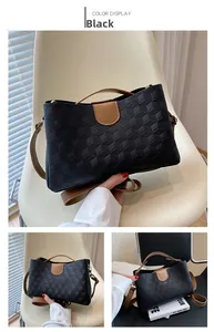 Detail of black tote bag with 3D geometric cube embossing and tan shoulder strap