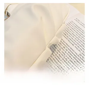 Detailed close-up showing soft ivory pleated leather texture and fine stitching of the handbag