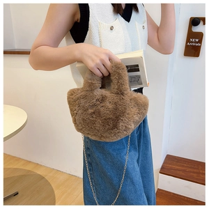 Makroaufnahme der braunen Plüschhandtasche mit goldener Kette für Damen im Herbst und Winter