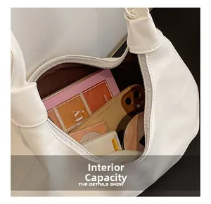 Top view of white ruched shoulder bag showing spacious interior with phone and cosmetics