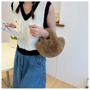 Braune Plüschhandtasche mit goldener Kette in einem stylischen Herbst-Outfit Kontext
