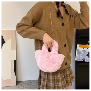 Detailansicht der rosa Plüsch-Umhängetasche mit goldener Kette an einem Model