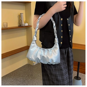 Close-up of metallic silver pleated cloud bag with chunky braided shoulder strap