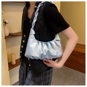 Detail of silver metallic ruched shoulder bag featuring a thick braided strap design