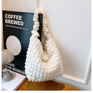 Close-up detail showing the soft puffy bubble texture and ruffled strap of this white bag