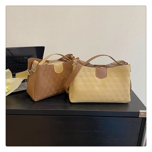 Detailed view of geometric embossed texture on stylish brown and beige handbags