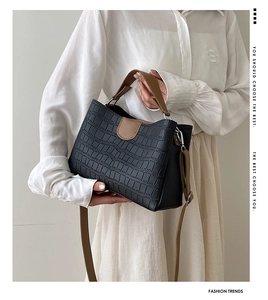 Détail du sac cabas vintage en cuir noir embossé crocodile avec bandoulière marron contrastée