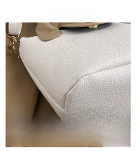 Vue détaillée des coutures serrées sur cuir grainé blanc avec détails marrons