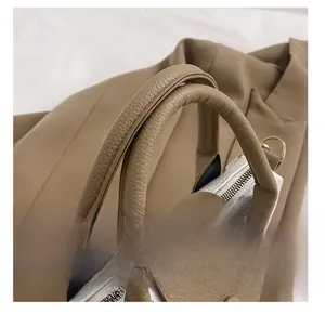 Gros plan sur le cuir grainé et les détails dorés du sac à main bicolore chic