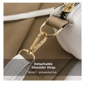 Détail de la texture cuir blanc et du crochet métallique doré amovible sur le sac à main