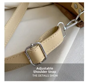 Détail de la bandoulière réglable en cuir beige avec boucle argentée et surpiqûres blanches