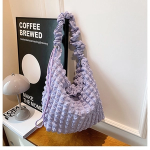 Close-up of the soft purple bubble texture fabric and ruched shoulder strap of this bag
