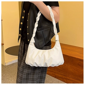 Detailed view of white pleated cloud bag with a unique woven braided handle strap