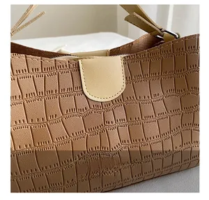Détail de la texture en cuir gaufré crocodile marron clair sur un sac à main chic