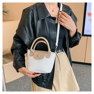 Gros plan d'un mini sac bandoulière blanc à texture de litchi avec détails beiges