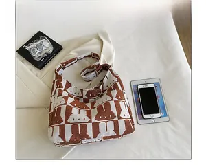 Capacity view of checkered rabbit knit tote bag holding an iPad, phone and book