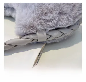 Détail macro de la bandoulière tressée en similicuir sur un sac en fausse fourrure