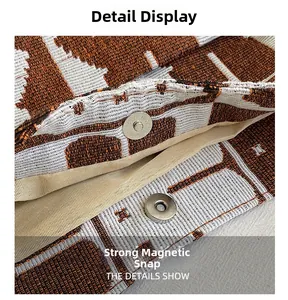 Detail of the magnetic buckle closure on a knitted orange and white giraffe print bag
